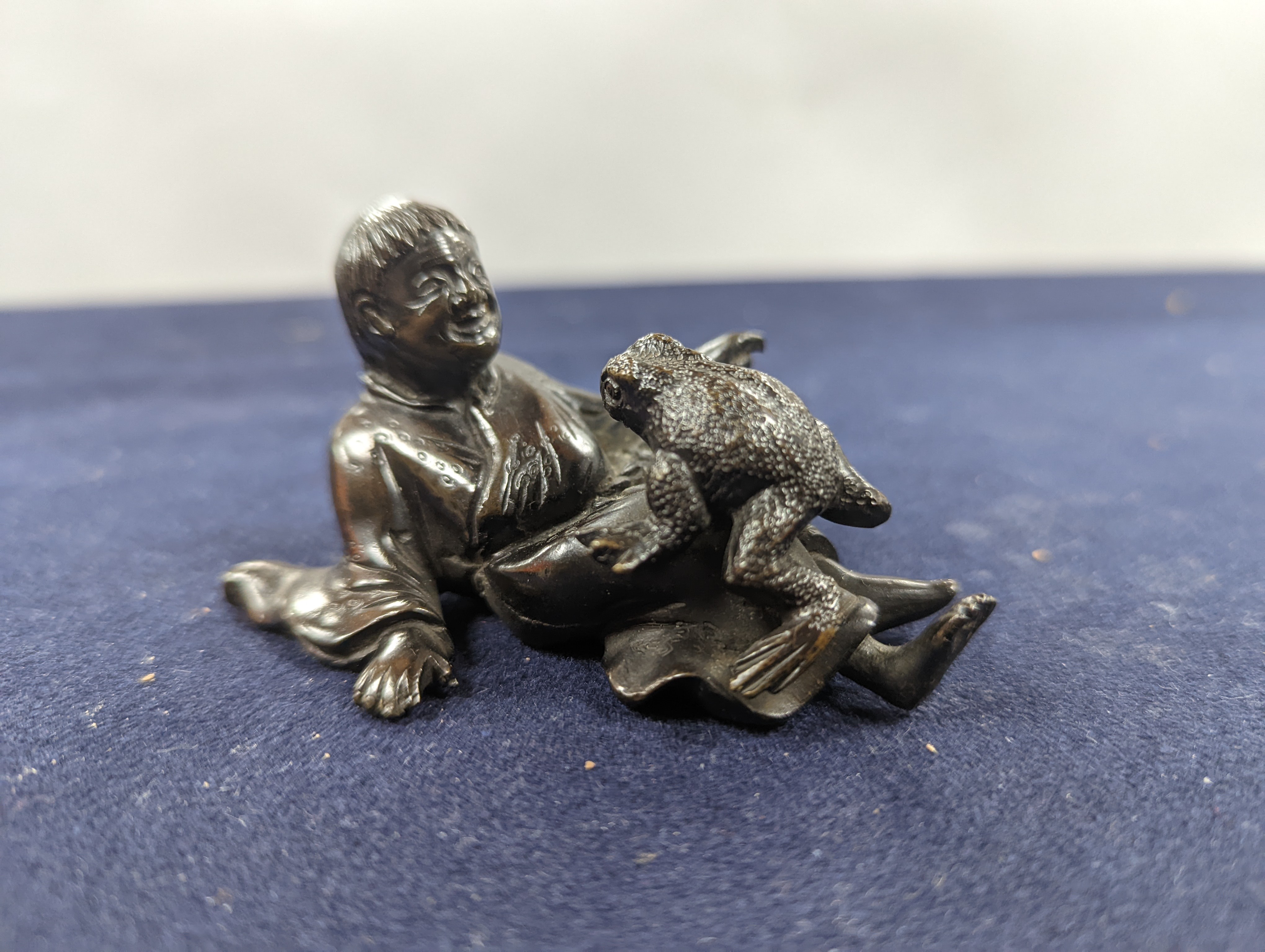 A Chinese bronze group of Liu Hai and a toad, wood stand and a bronze figure of a dog, 9cm